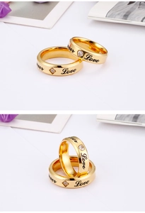 Detail of couple rings in gold finish with Forever Love engraving and zircon stones