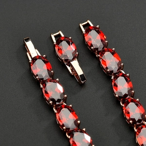 Macro detail of oval cut red garnet zircon set in a rose gold plated clasp bracelet