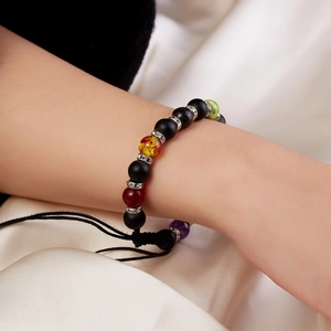 Close-up of beaded bracelet with colorful stone beads and black braided rope on wrist