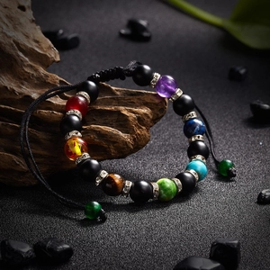 Handcrafted seven chakra beaded bracelet with matte stones and magnetic clasp on dark rock