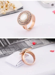 Detail of rose gold stainless steel ring with white cat eye stone and double pavé rhinestones