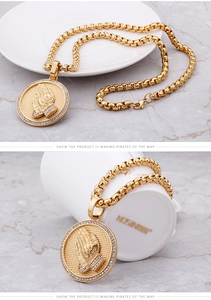 Vue macro du collier hip hop doré avec pendentif mains en prière et pierres en zircone
