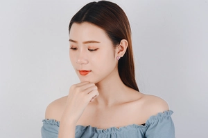 Detail showing pink flower stud earrings with zircon inlay worn by a model