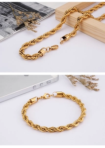 Detailed view of gold twisted rope chain necklace and bracelet on a wooden tray decor