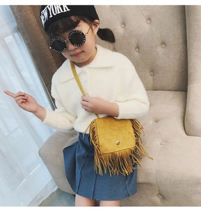 Girl wearing a mustard yellow fringe crossbody bag with suede finish and long tassels