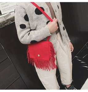 Detail showing red suede kids crossbody bag with long fringes and metal buckle clasp