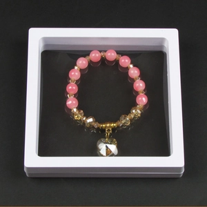 Pink cat eye bead bracelet with heart pendant in a white square PE film floating display box