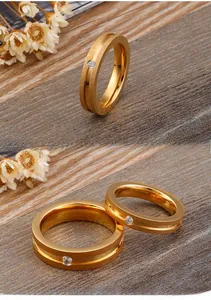 Macro detail of gold plated couple rings featuring matte finish and inset zircon stone