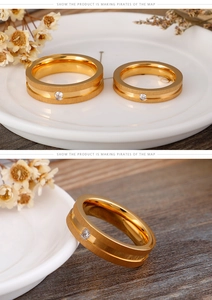 Detail view of gold stainless steel couple rings with matte finish and small center crystal