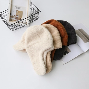 Vista dall'alto di cappelli con paraorecchi in lana di agnello in beige, marrone e grigio