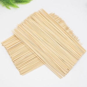 Natural carbonized bamboo BBQ skewers neatly arranged on white background