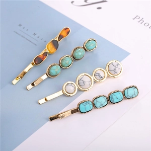 Detail of vintage gold alloy hair clips with amber and turquoise style resin stones