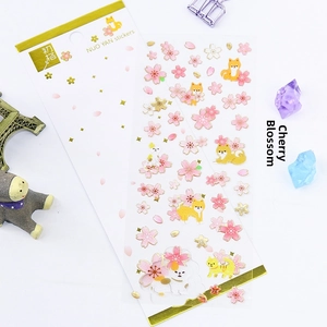 Detail view of 3D gold-stamped cherry blossom and shiba inu stickers for journaling