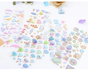 Detail of 3D gold-stamped ocean life stickers featuring whales and dolphins