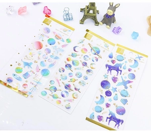 Detail of colorful gold foil stickers with starry space and unicorn designs
