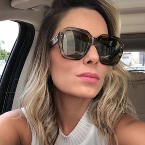 Close-up of tortoise shell cat-eye sunglasses worn by a woman inside a car