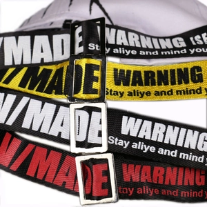Graffiti baseball cap featuring industrial nylon straps with metal buckles and printed text