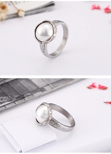 Detail view of retro silver shell ring featuring bark texture and large white round pearl