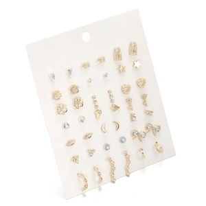 Detailed close-up of gold geometric earring set with stars and pearls on display card