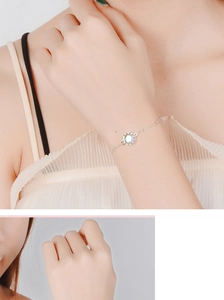 Close-up of silver crown bracelet with glowing moonstone on a female wrist