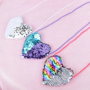 Detailed view of heart-shaped sequin mini bags in white, blue, and rainbow colors