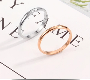 Close-up of smooth 18K rose gold and silver stainless steel rings on a display card