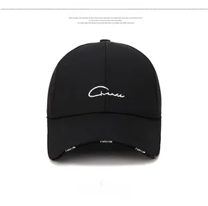Detail of black cotton baseball cap featuring white script embroidery and FASHION brim text