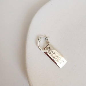 Macro view of vintage 925 sterling silver rectangular earrings with engraved lettering