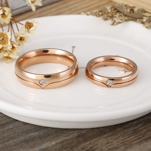 Minimalist rose gold stainless steel couple rings set with round zircon on ceramic tray