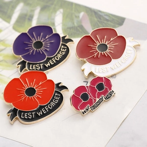 Macro detail of poppy enamel brooches with Lest We Forget text and colorful floral designs