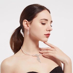 Detailed view of silver rhinestone necklace set and earrings on a professional model