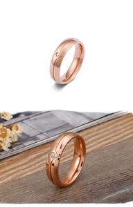 Macro shot of rose gold titanium ring featuring a center groove and a single inset diamond