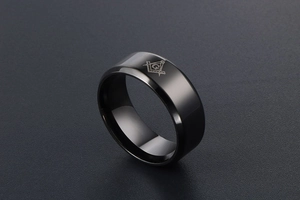 Makroaufnahme: Polierter schwarzer Titanring mit graviertem Freimaurer-Logo aus Zirkel und Winkel
