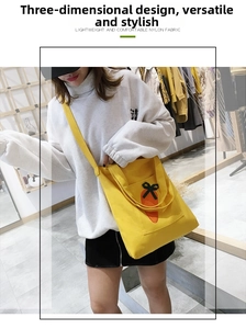 Close-up of yellow nylon tote bag featuring a cute orange carrot and black bow detail