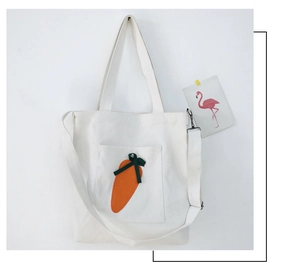 Vertical off-white canvas tote bag with cute orange carrot patch and green ribbon bow