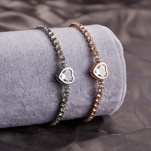 Detail of silver and rose gold heart tennis bracelets with zircon stones on velvet
