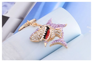 Macro detail of shark keychain with sparkling clear and purple crystal rhinestones