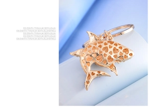Detailed macro view of a rose gold shark keychain featuring intricate heart cutouts