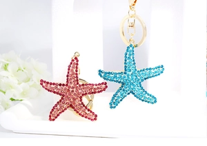 Starfish keychains with red and blue rhinestones and gold-tone lobster clasps