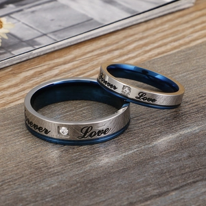 Forever Love couple rings with blue inner band and zircon on a wood texture