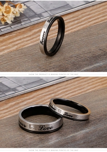 Détail de bagues de couple avec gravure Forever Love et zircone sur fond de bois