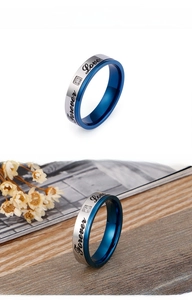 Macro detail of Forever Love engraved silver and blue couple ring with small zircon stone