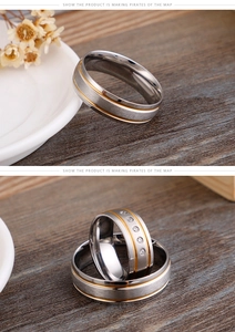 Detail of brushed gold and silver stainless steel couple rings with small zircon inlays