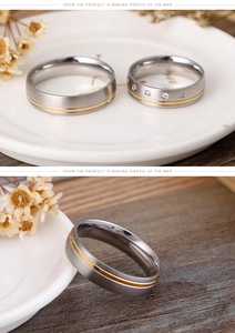 Detail of frosted stainless steel couple rings with gold line and clear crystals