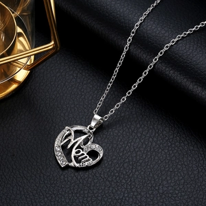 Collier cœur argenté avec lettrage MOM et strass scintillants sur un fond en cuir noir