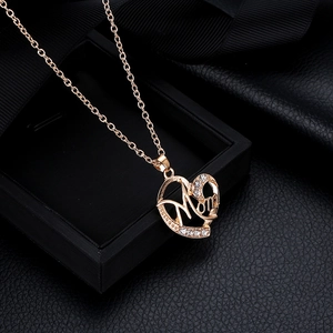 Détail du pendentif en forme de cœur Mom avec cristaux sur fond de boîte à bijoux noire