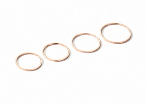 Macro view of four stacked 18K rose gold minimalist bands on a white background