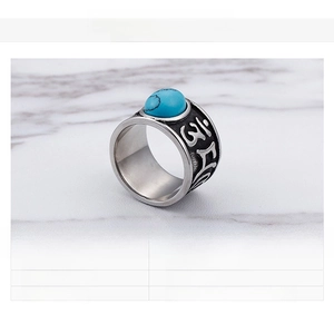 Detail showing vintage stainless steel ring with oval synthetic turquoise and relief text