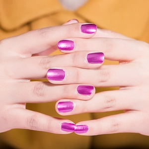 Close-up of hands showing metallic bright purple mirror finish nail polish on nails