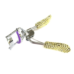 Detail view of silver metal eyelash curler with gold beaded handle and purple silicone pad